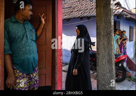 Neighbors talking in front of their homes, Kochi, India Stock Photo