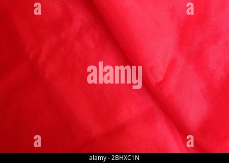 Vibrant red charmeuse fabric with wrinkles and creases suitable for background, celebration concept Stock Photo