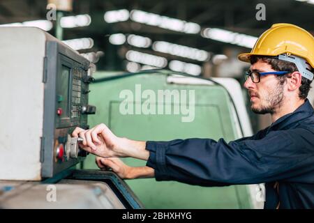 young profession technician engineer operate heavy machine to automated CNC in factory, close-up worker hand. Stock Photo