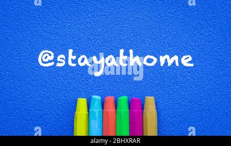Stay at home. Words or typed text on blue board. Colorful crayons. Top view. Education concept.. Stock Photo