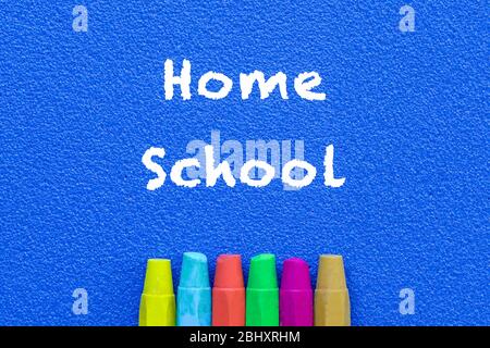 Homeschool. Words or typed text on blue board. Colorful crayons. Top view. Education concept. Stock Photo