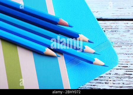 Turquoise crayons and diary on wooden table, closeup Stock Photo