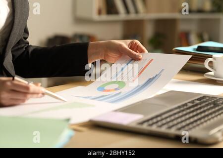 Close up of entrepreneur woman hands comparing growth graph reports on a desk at home office Stock Photo