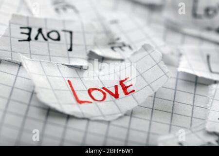 Word LOVE written on torn paper, closeup Stock Photo