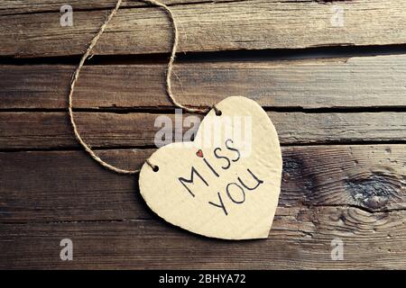 Written message on cardboard heart on wooden background Stock Photo