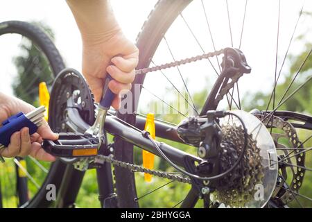 Man hands repairing the bike by repair key, doing maintenance of his bicycle Stock Photo