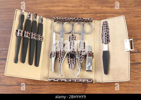 Manicure set in open case on wooden table, closeup Stock Photo