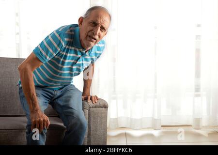 Senior man trying to stand up with a knee pain. (Health and fitness) Stock Photo