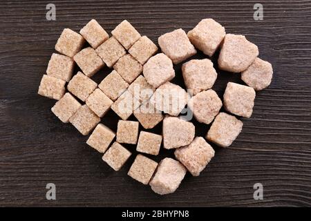 Sugar cubes in heart shape on wooden background Stock Photo