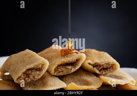 Coconut filled patishaptas with honey dripping on top. Stock Photo