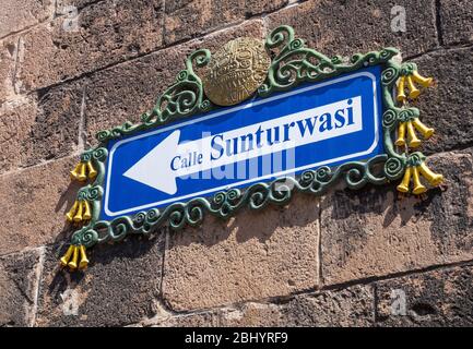 Decorative street sign for Calle Sunturwasi, surrounded by a decorative pattern of yellow honeysuckle flowers in Cusco, Peru Stock Photo