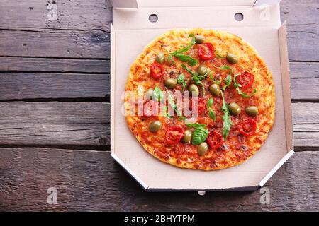 Pizza in box on wooden table, top view Stock Photo
