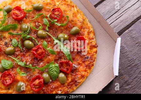 Pizza in box on wooden table, closeup Stock Photo