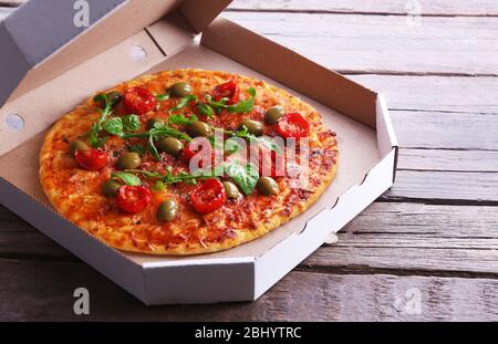 Pizza in box on wooden table, closeup Stock Photo