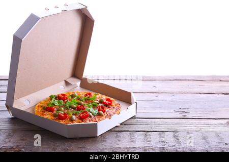 Pizza in box on wooden table isolated on white Stock Photo