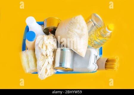 Crisis food stock for quarantine isolation period on yellow background. Food supplies. Rice, pasta, canned food, sugar, oil, milk. Food delivery, Dona Stock Photo