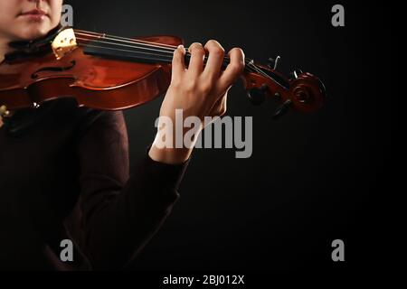 Violinist playing violin on dark background Stock Photo