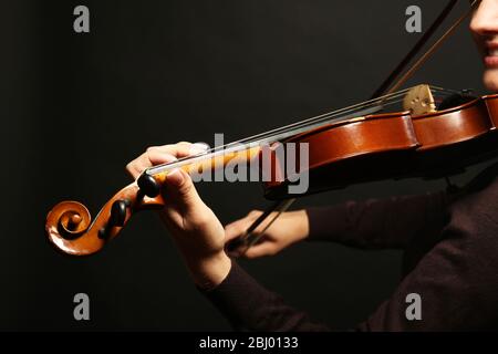 Violinist playing violin on dark background Stock Photo