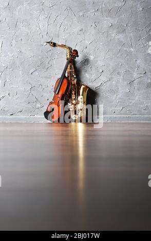 Violin and saxophone on gray wall background Stock Photo
