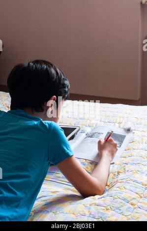 Boy doing his homework using digital tablet.  Stock Photo