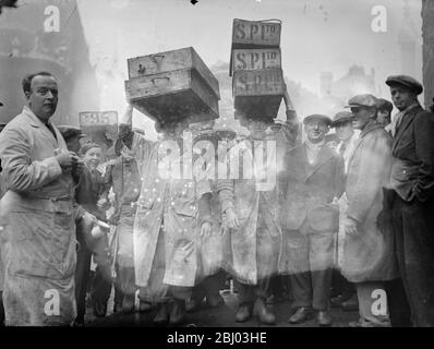 Billingsgate Fish Market is already working at top pressure to deal with the terrific demand for Good Friday fish . The approach of the Easter festival means greatly increased work for Billinsgate , which has to supply eight million Londoners . Photo shows , the busy scene at Billingsate Market . - 4 April 1936 Stock Photo