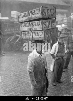 Billingsgate Fish Market is already working at top pressure to deal with the terrific demand for Good Friday fish . The approach of the Easter festival means greatly increased work for Billinsgate , which has to supply eight million Londoners . Photo shows , the busy scene at Billingsate Market . - 4 April 1936 Stock Photo