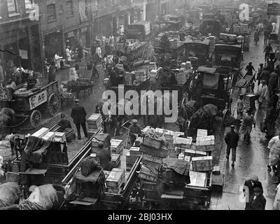 Billingsgate Fish Market is already working at top pressure to deal with the terrific demand for Good Friday fish . The approach of the Easter festival means greatly increased work for Billinsgate , which has to supply eight million Londoners . Photo shows , the busy scene at Billingsate Market . - 4 April 1936 Stock Photo