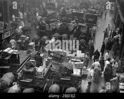 Billingsgate Fish Market is already working at top pressure to deal with the terrific demand for Good Friday fish . The approach of the Easter festival means greatly increased work for Billinsgate , which has to supply eight million Londoners . Photo shows , the busy scene at Billingsate Market . - 4 April 1936 Stock Photo