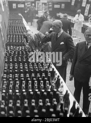 Ten tons of beer, contained in seven thousand pint bottles form all over the world, is being judged in the bottled beer competition at the allied brewery trades association, Southwark Street, S.E. - 8 October 1937. Stock Photo