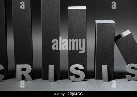 Crisis word over falling 3d bar chart made in black color over shades of gray Stock Photo