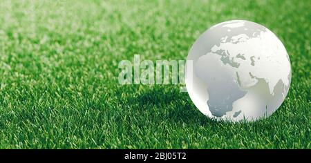 Glass globe or earth in green grass showing eco concept with copyspace, 3d rendering Stock Photo