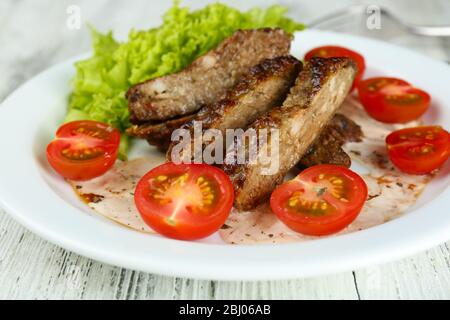 Tasty slices of meat with sauce and cherry tomato on table close up Stock Photo
