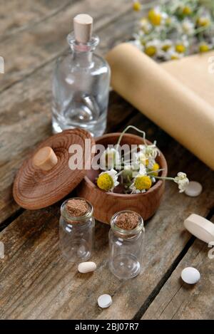 Dry flowers in mortar with tablets on table close up