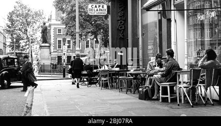 Despite the weather conditions which are more like winter in London , a few hardy people are seen taking their tea outside at this cafe near Hanover Square , London , England - 16 July 1963 Stock Photo