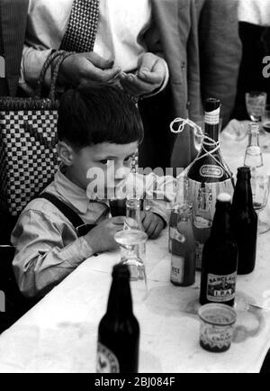 London's Italian colony hold picnic at California, Berkshire. 1954 - Scampanata, the big annual picnic of the Mazzini, Garribaldi Club, held at California, Berks. Over 500 Italians of London's Little Italy attended the picnic. - There are fruit drinks for the bambinos, but one young intruder at the bar prefers chianti! Stock Photo