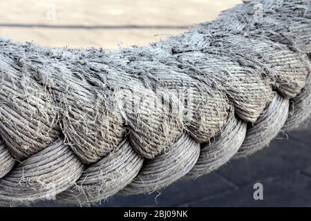 Close up of a strong rope hanging in the air, horizontally adividing the image frame with a slight curve. Stock Photo