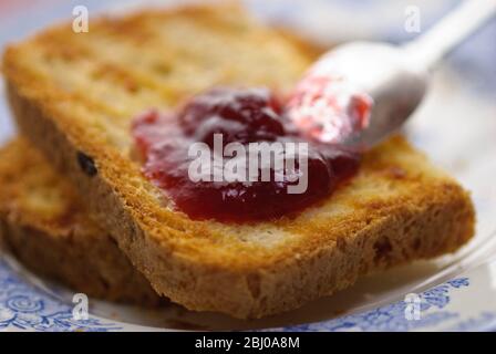 Home made jam on toast made from gluten free bread with silver spoon Stock Photo