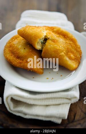 Portuguese snack food, empanadas de camarao, shrimp pasties on white plate - Stock Photo