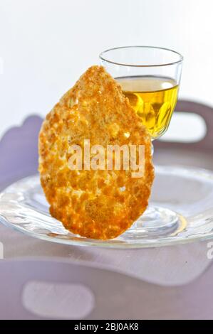 Tuile biscuit with small glass of dessert wine on glass plate - Stock Photo