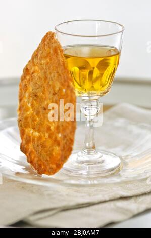 Tuile biscuit with small glass of dessert wine on glass plate - Stock Photo