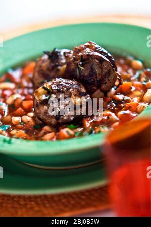 Grilled noisettes of lamb on mixed beans with tomatoes and herbs - Stock Photo