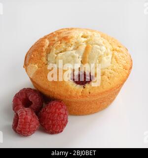 Raspberry and white chocolate muffin on white surface - Stock Photo