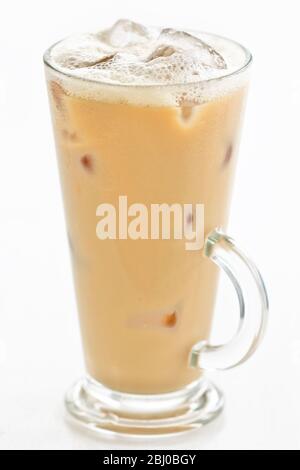 Iced latte in tall glass with handle on white background - Stock Photo