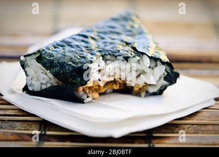 Japanese lunchtime snack of rice and salmon wrapped in seaweed - Stock Photo