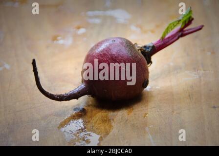 Whole fresh raw beetroots on wooden board - Stock Photo