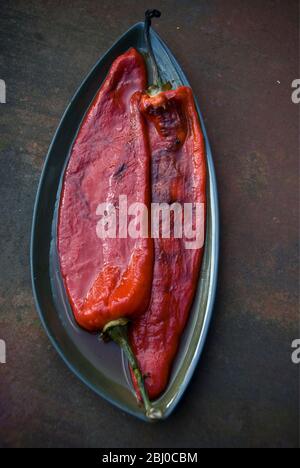 Grilled red peppers with blistered skins removed - Stock Photo