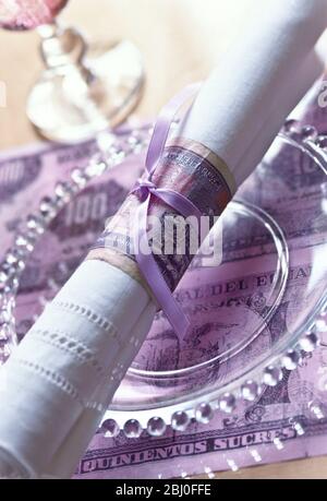 Napkin ring and place mat made from old foreign bank notes - Stock Photo