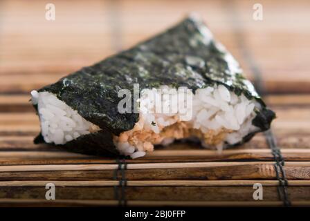 Japanese lunchtime snack of rice and salmon wrapped in seaweed - Stock Photo