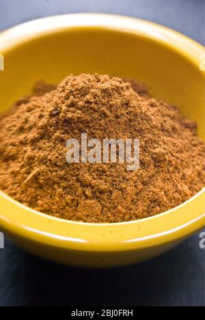 Ras-el-harnout (North African spice mixture), in small yellow bowl - Stock Photo