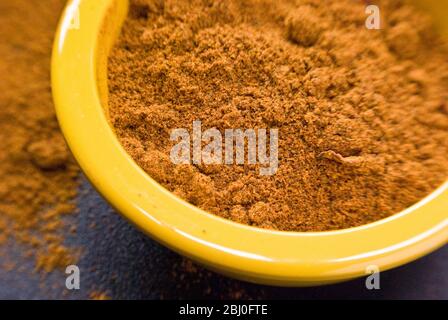 Ras-el-harnout (North African spice mixture), in small yellow bowl - Stock Photo